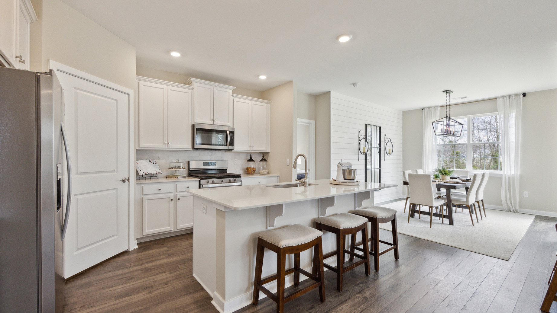 White kitchen with white kitchen island and stainless steel appliances