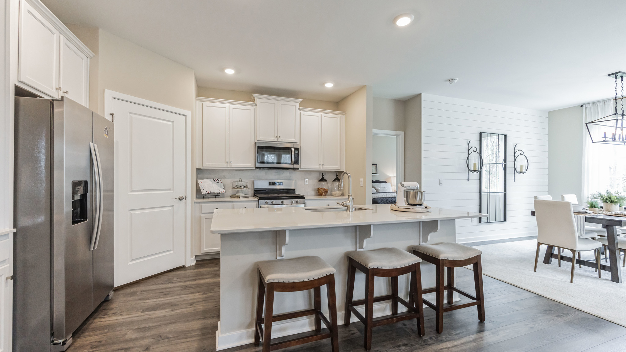 White kitchen with white kitchen island and stainless steel appliances