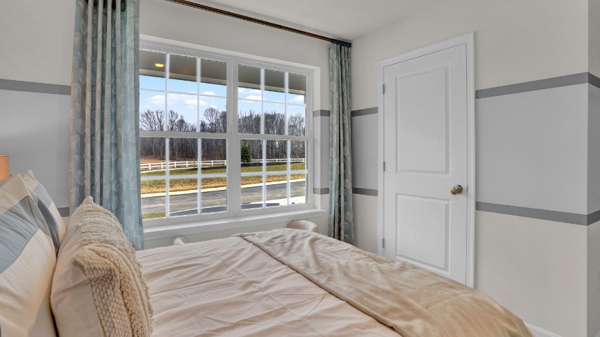 spacious bedroom with large windows and coastal design