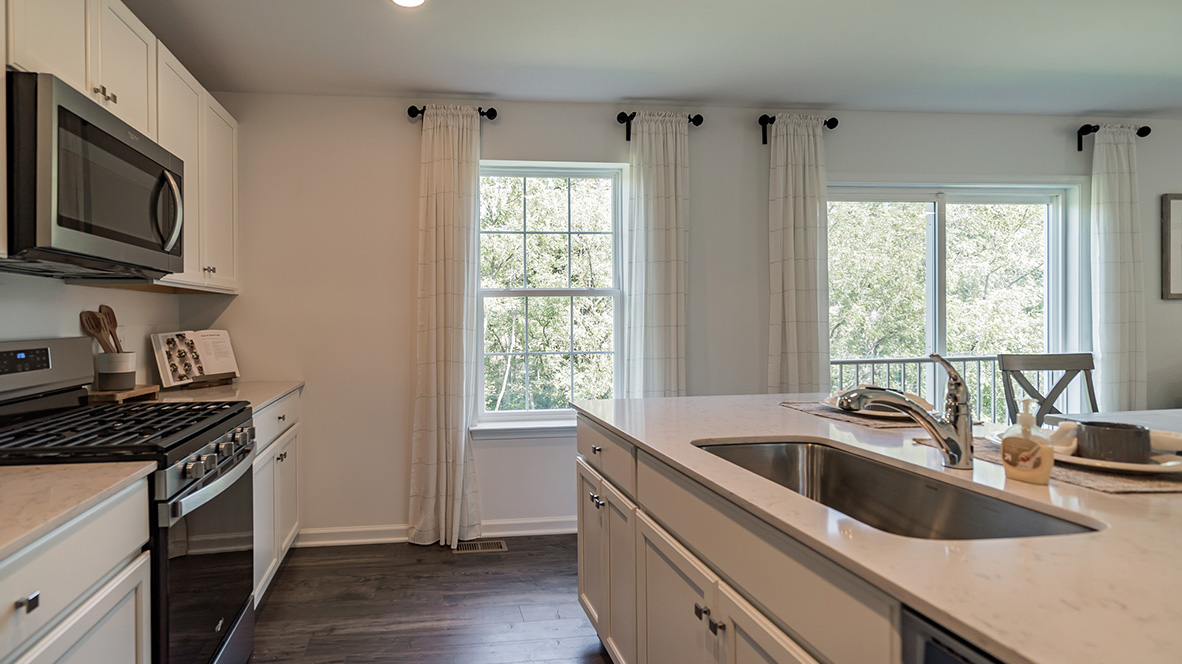 large kitchen island with white cabinetry and stainless steel appliances