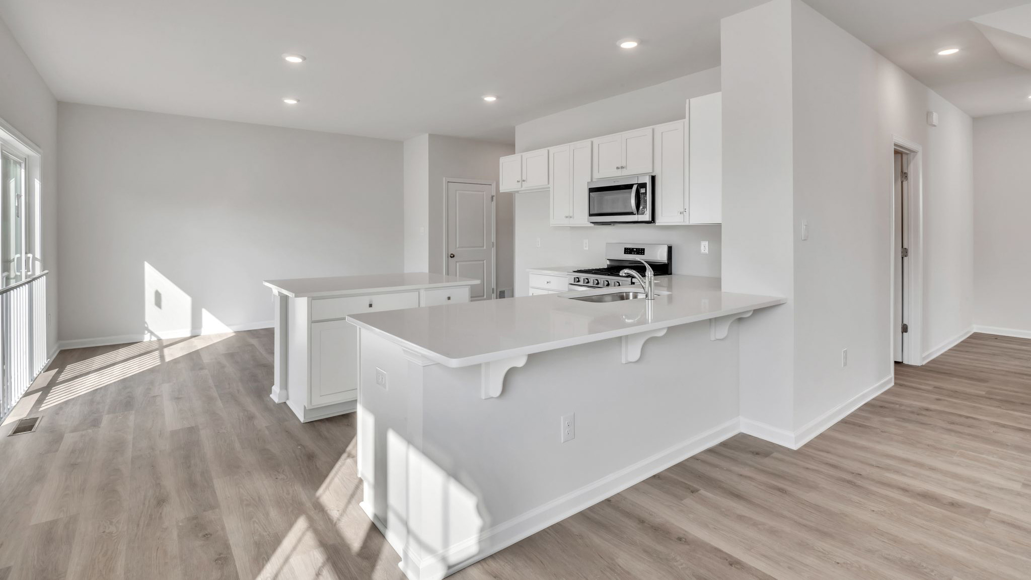 spacious first floor layout with hardwood throughout and a large quartz kitchen island in the center