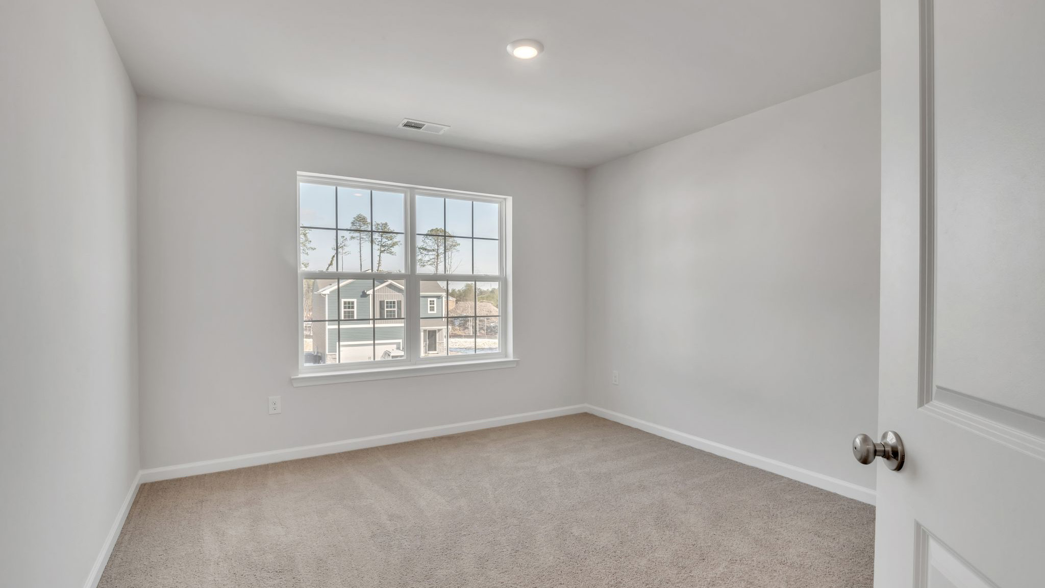 upstairs bedroom with neutral carpet, spacious closets and large windows