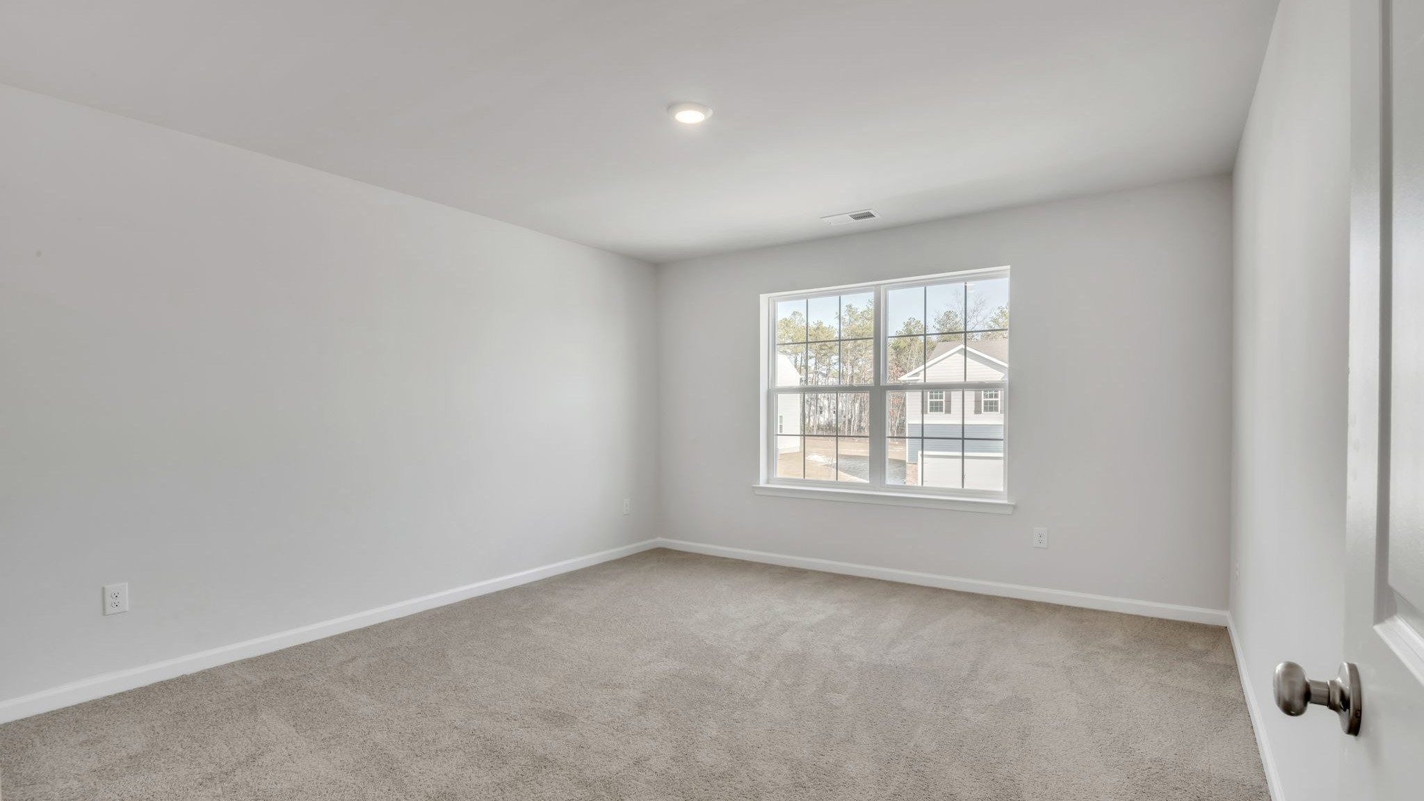 upstairs bedroom with neutral carpet, spacious closets and large windows