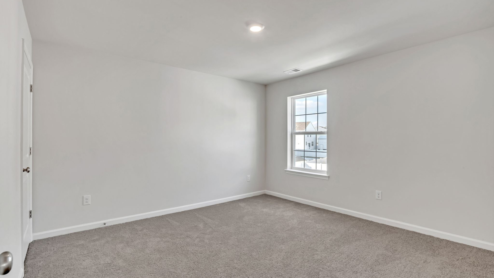 upstairs bedroom with neutral carpet, spacious closets and large windows