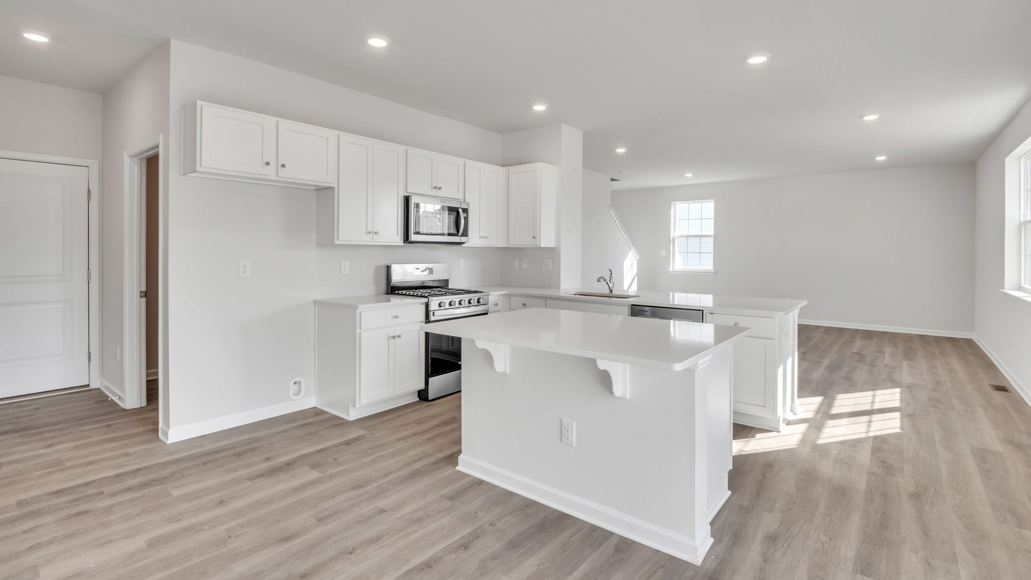 spacious first floor layout with hardwood throughout and a large quartz kitchen island in the center