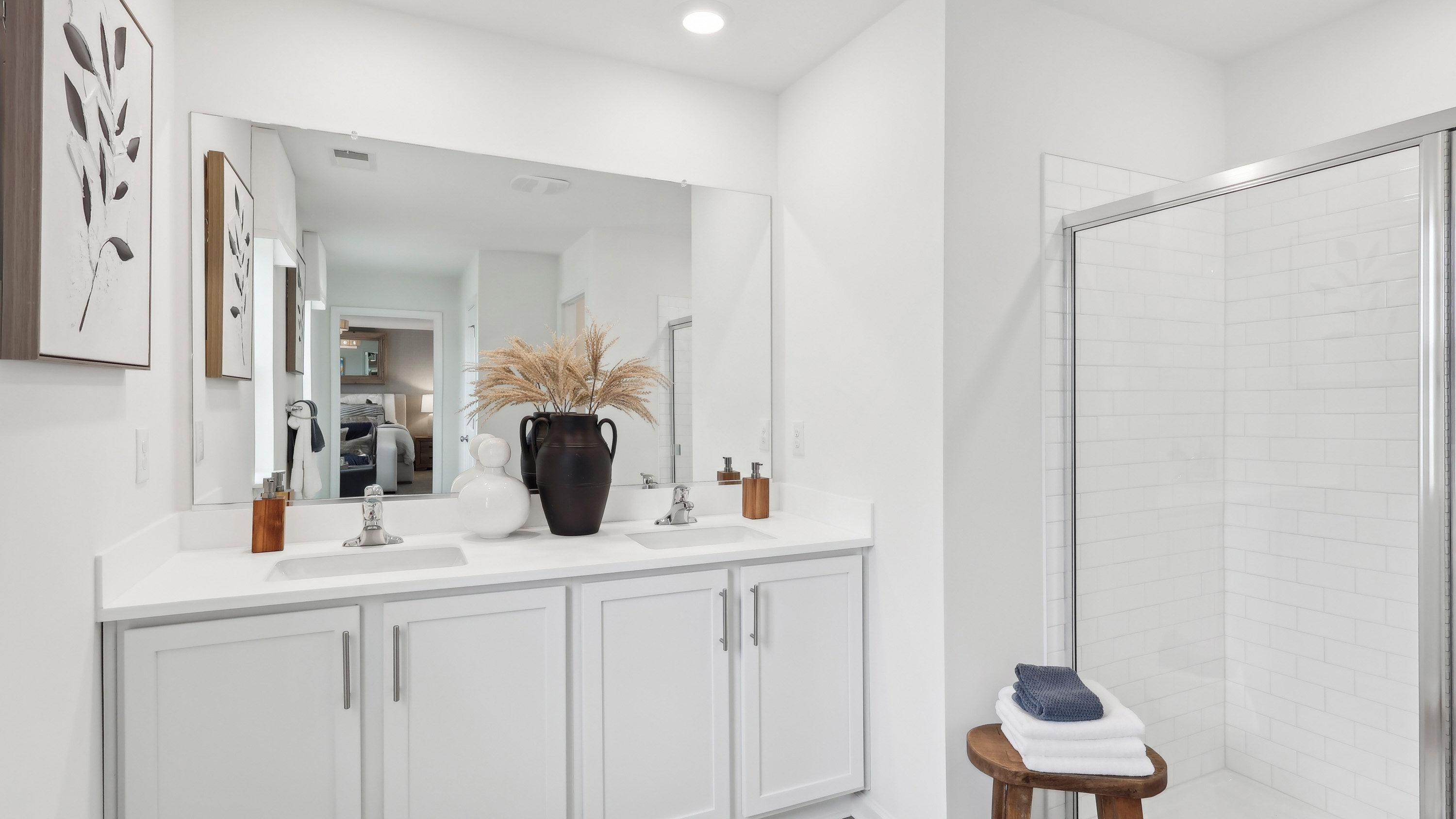 full bath off the primary suite with double vanity and white accents