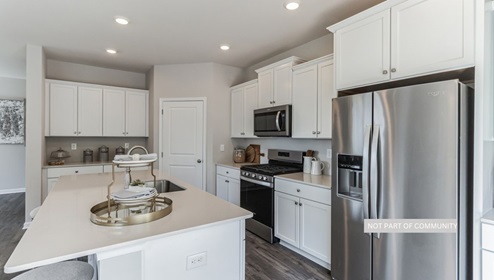 white kitchen with island and stainless steal appliances