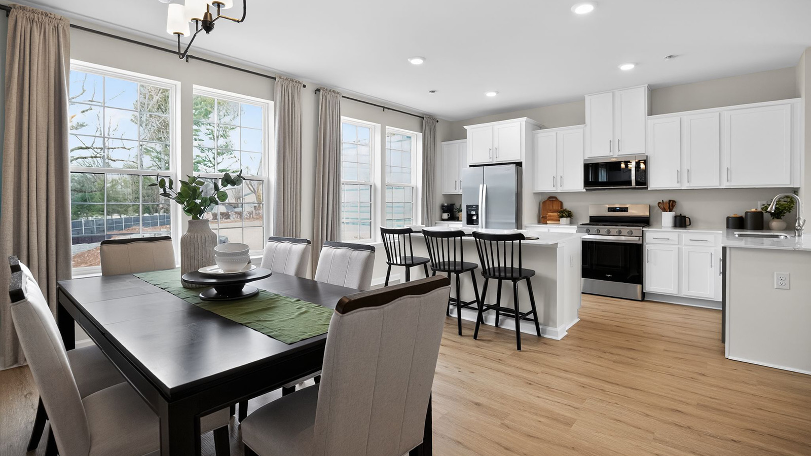 spacious kitchen with large island and dining table tucked behind