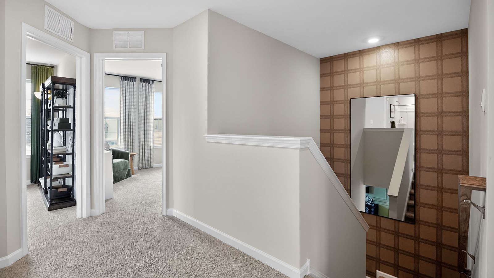 third floor landing showcasing the beautiful accent wall and mirror as the ascend the stairs