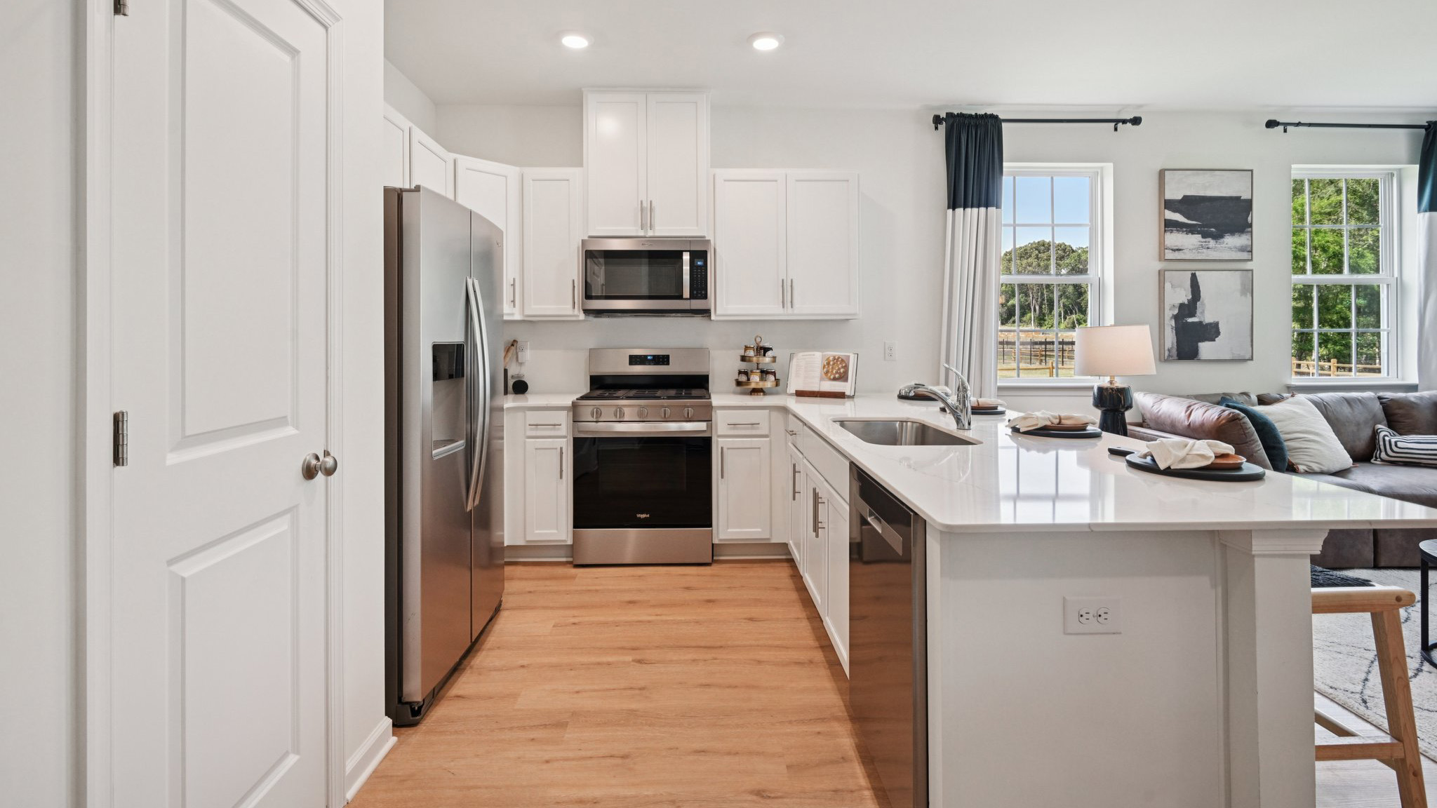 large kitchen island with white cabinetry and stainless steel appliances
