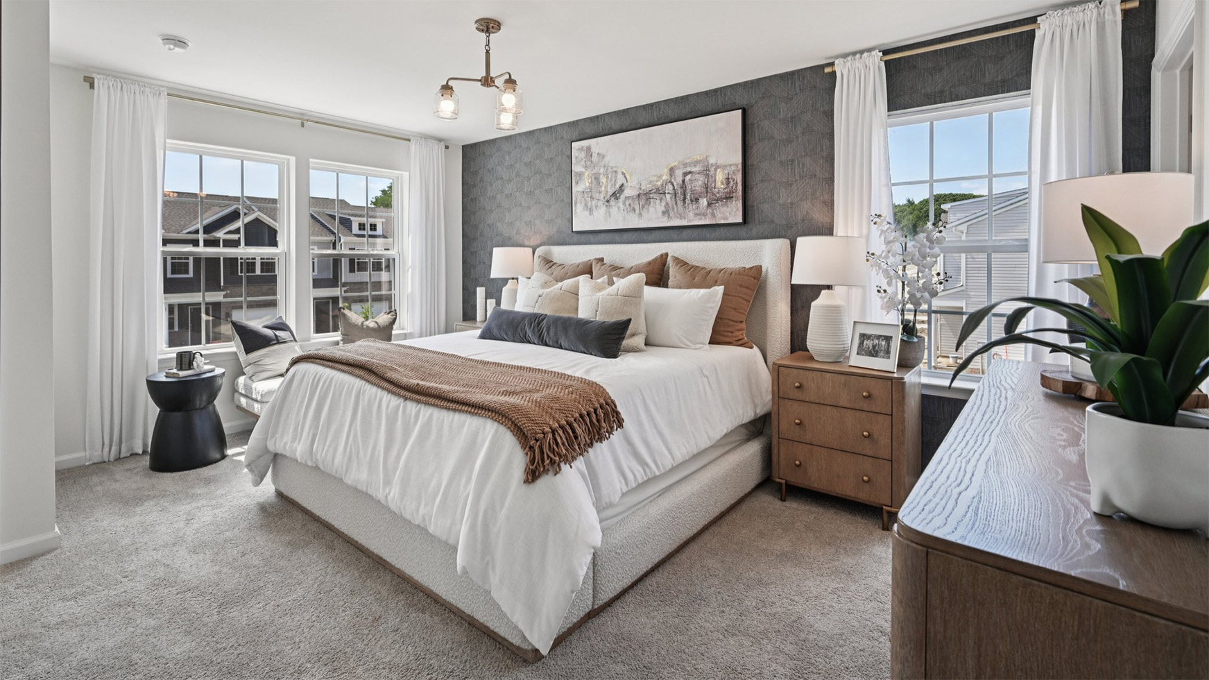 primary bedroom with large windows, walk in closet and full bath with double vanity