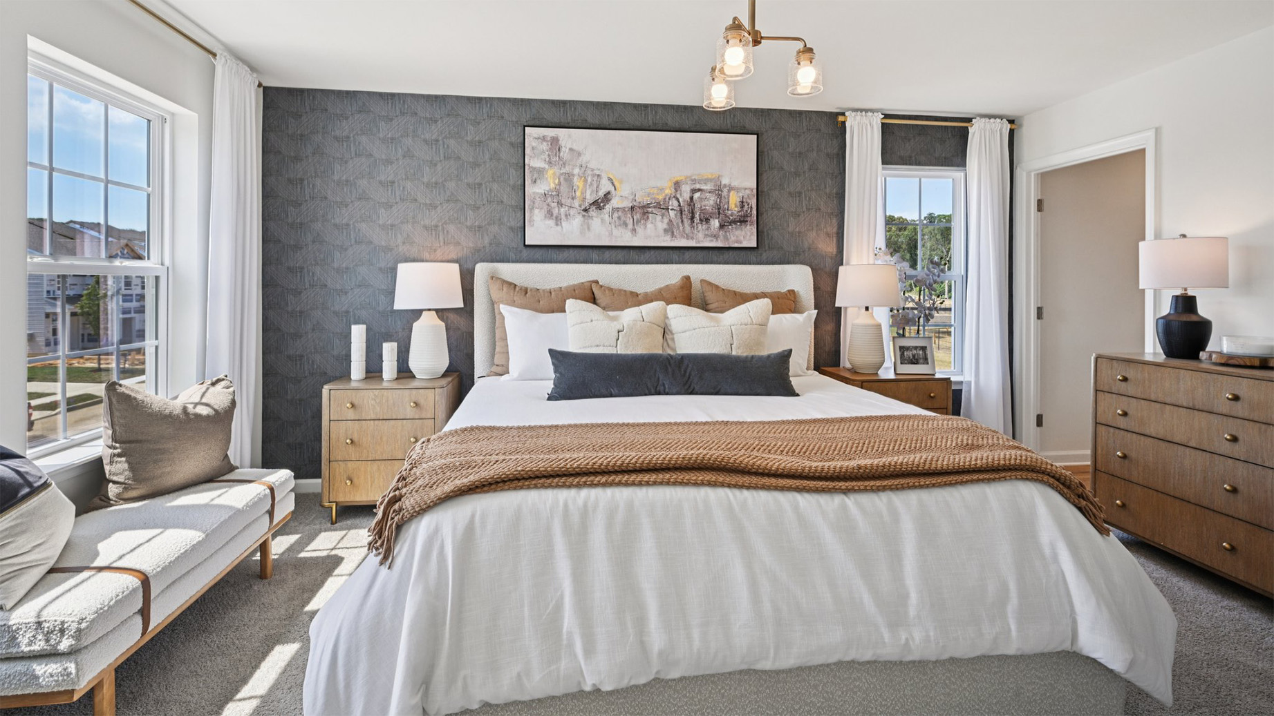 primary bedroom with large windows, walk in closet and full bath with double vanity