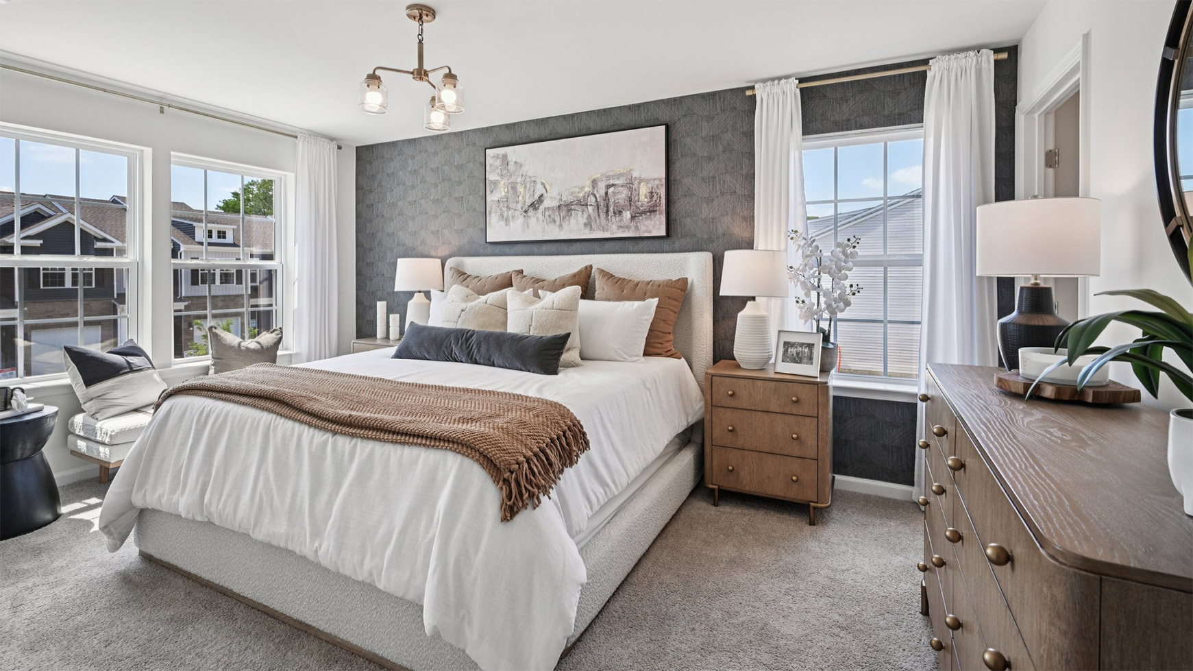primary bedroom with large windows and neutral color tone and dark accents