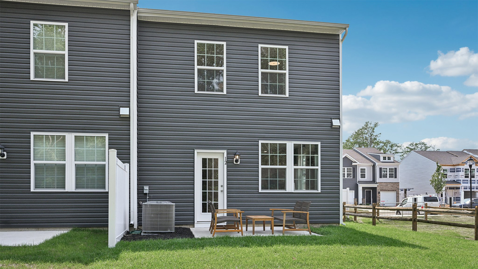 outside patio fenced in with seating and green spaces