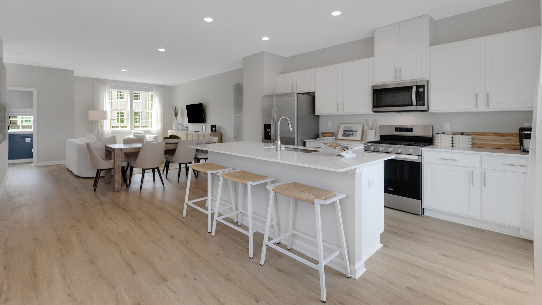 spacious kitchen with large island and open concept living room behind
