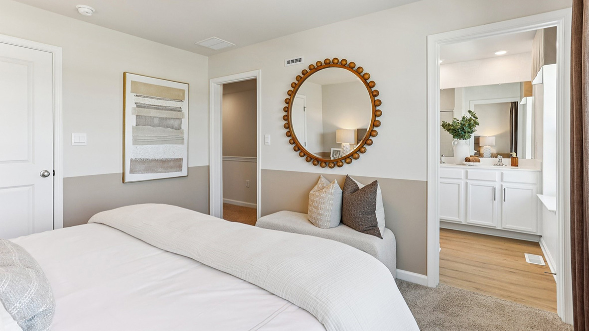 spacious primary bedroom with neutral tones and full bath