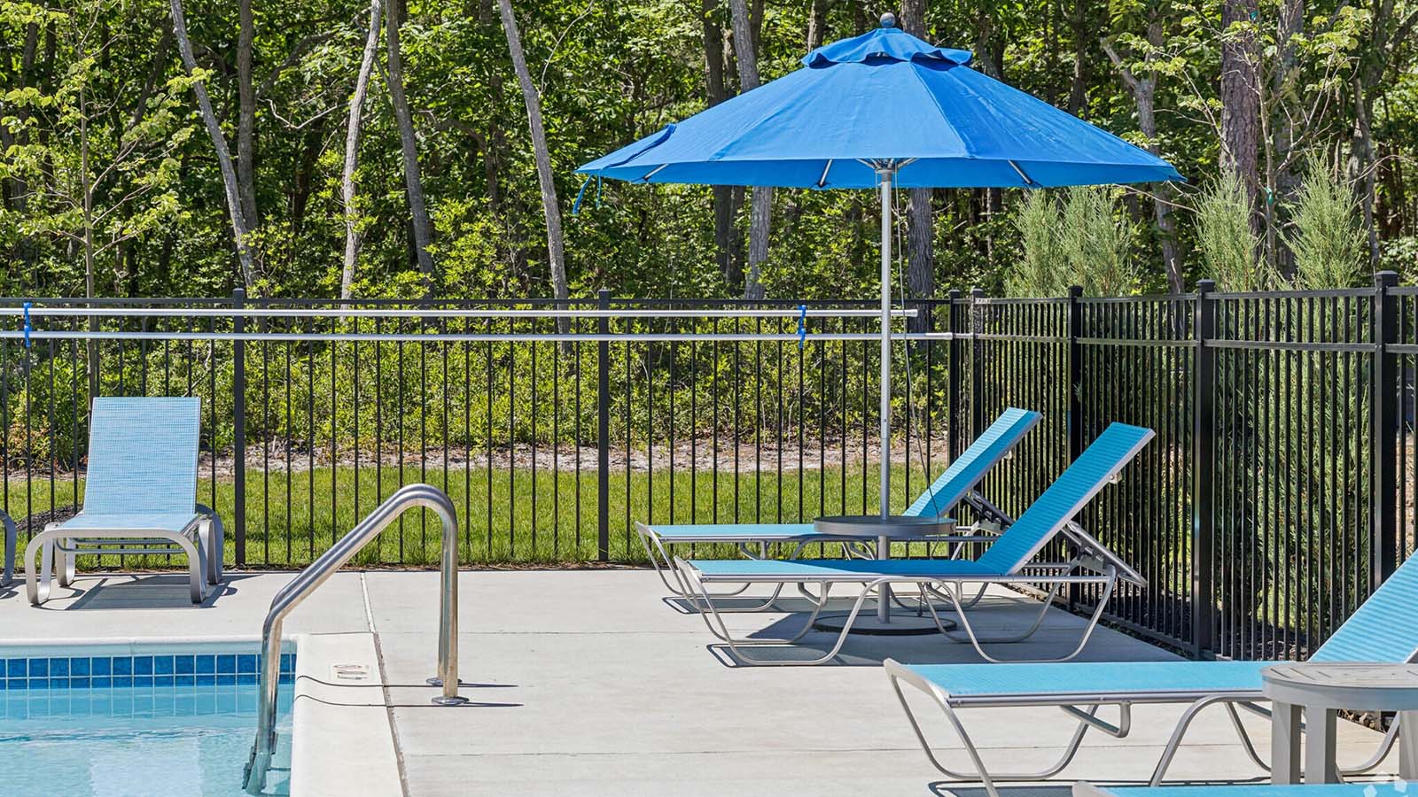 pool and blue umbrella with seating