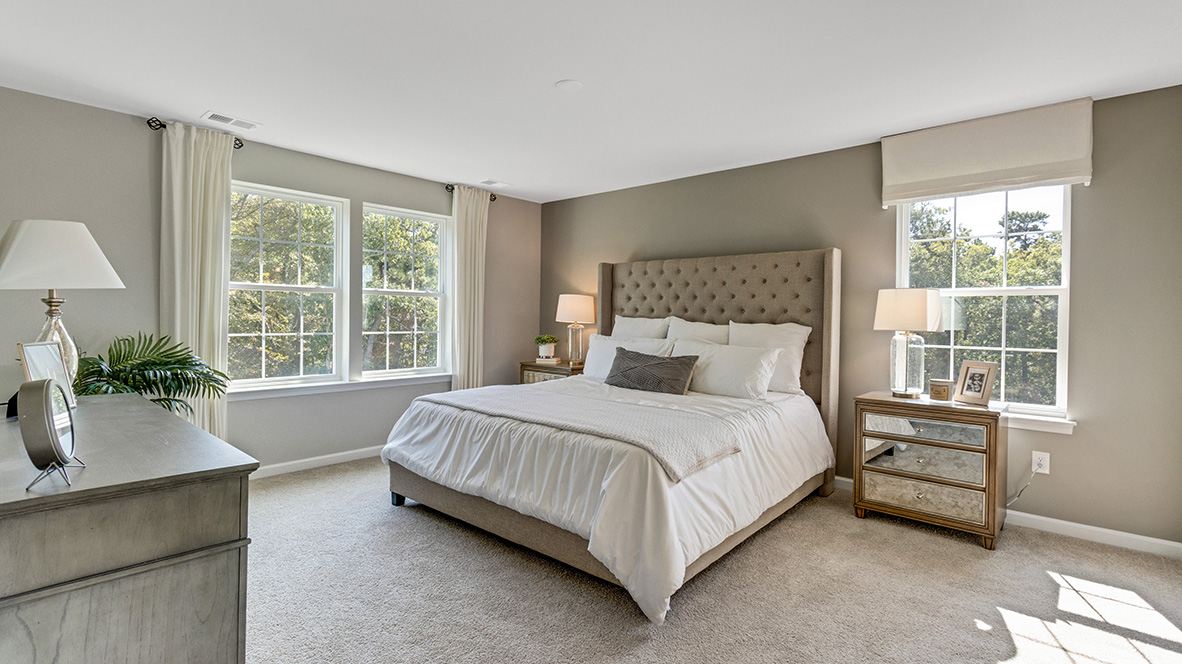 primary bedroom with large windows and ample space