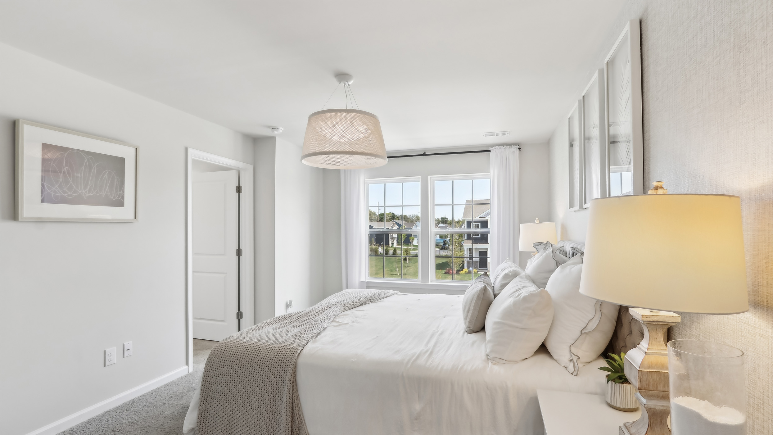 primary bedroom with neutral colors and light fixture
