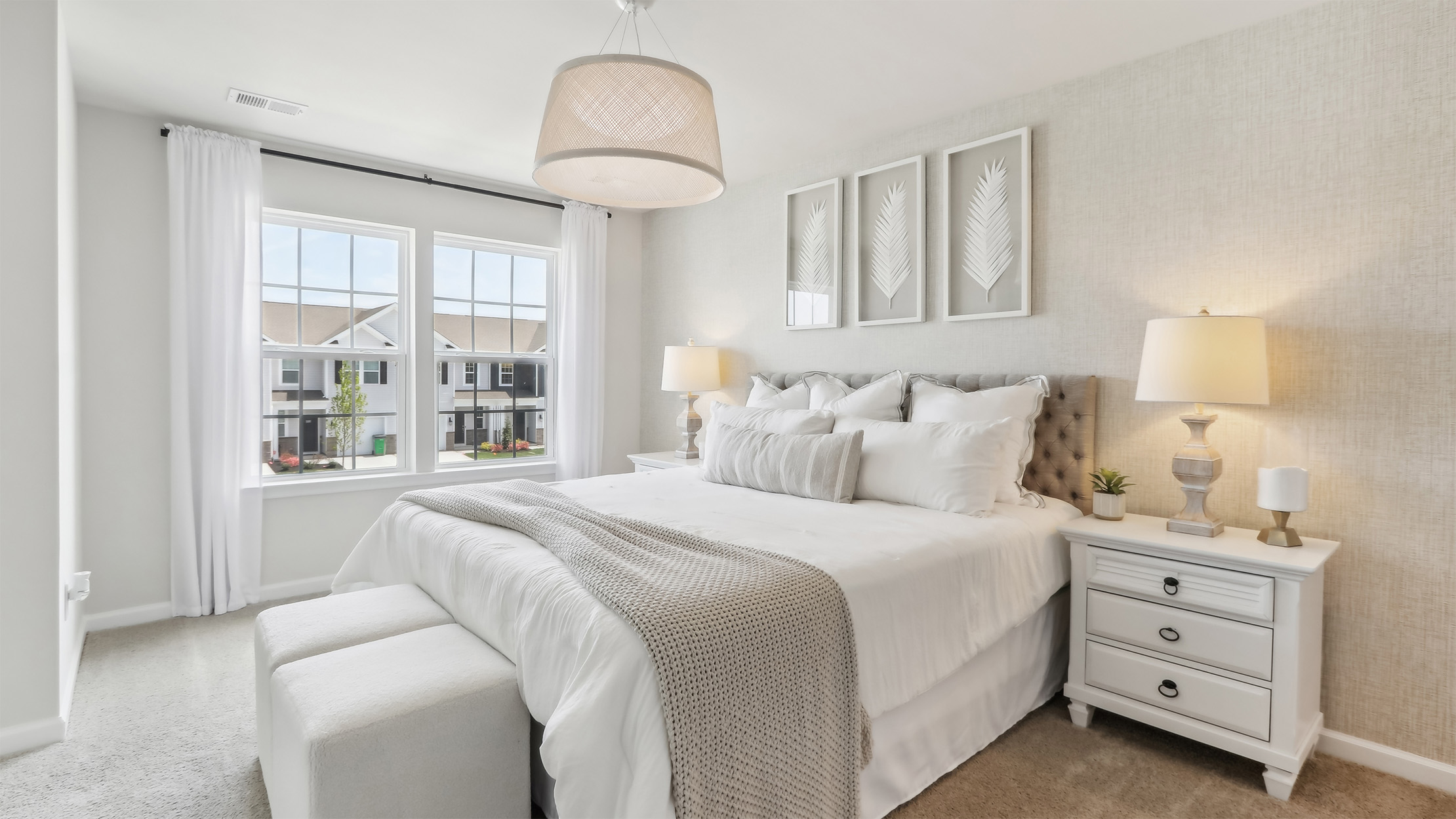 primary bedroom with neutral tones, large windows, and light fixture