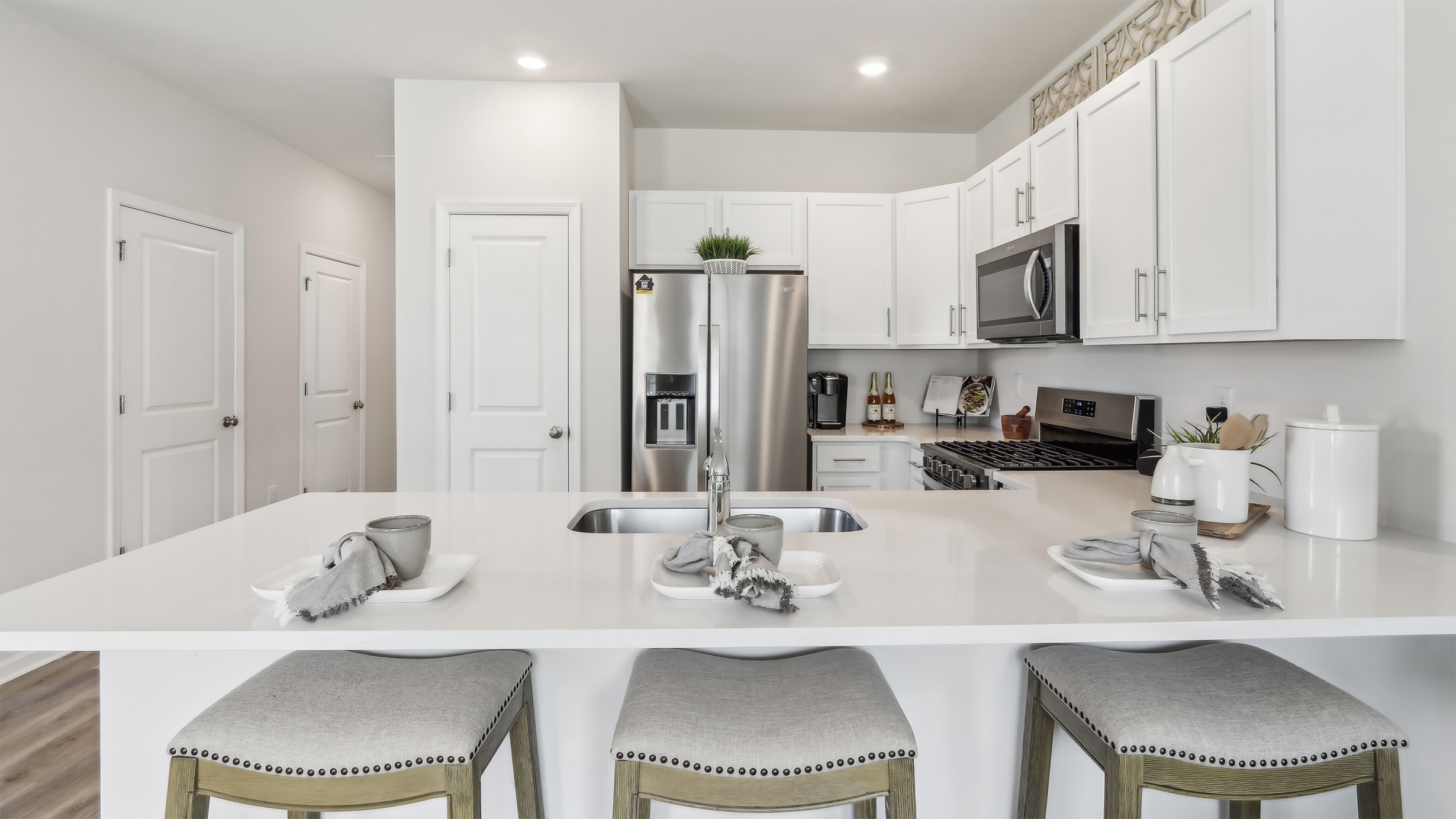 large kitchen island with white cabinetry, stainless steel appliances, and large pantry