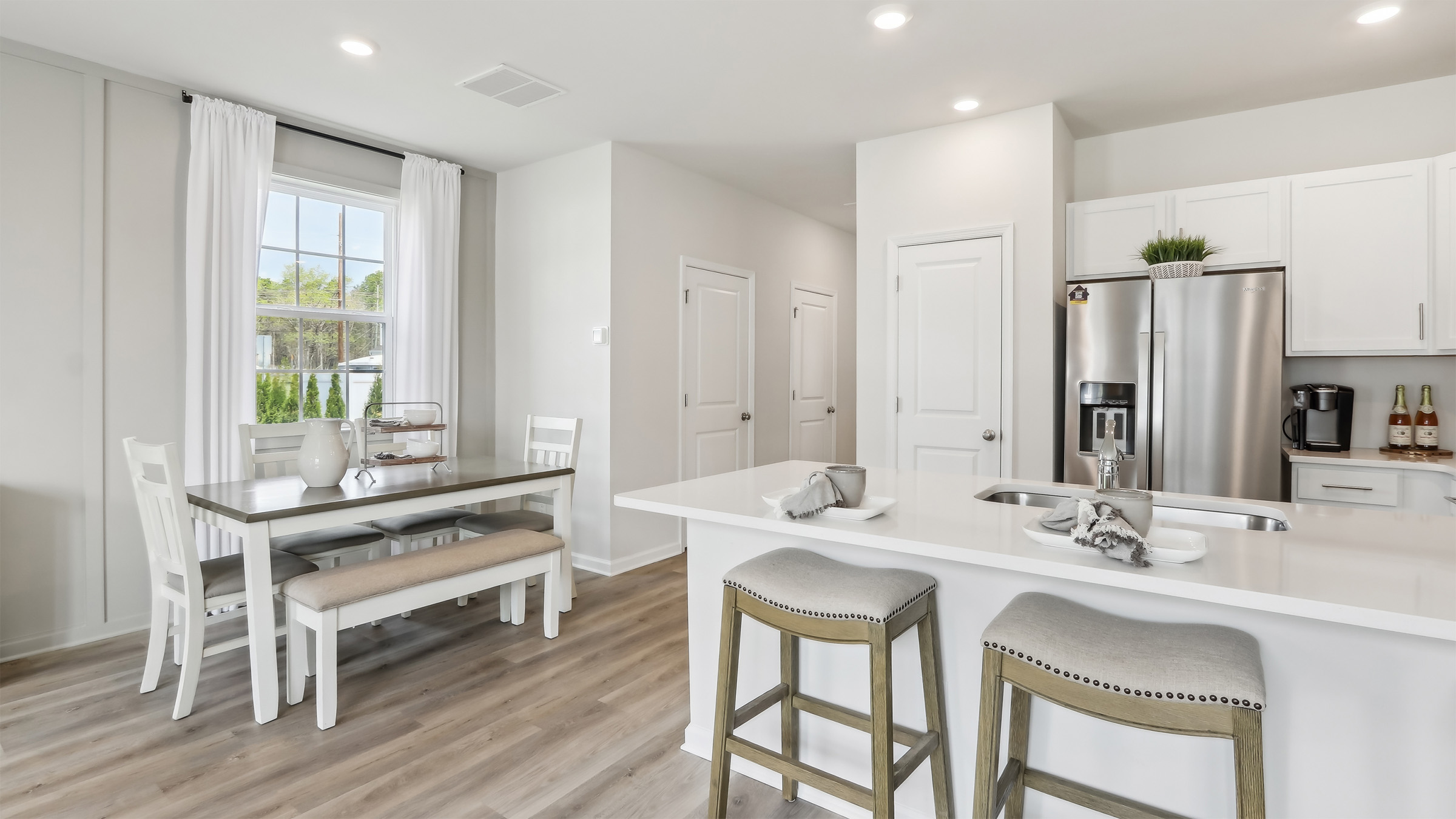 large kitchen island with white cabinetry, stainless steel appliances, and large pantry