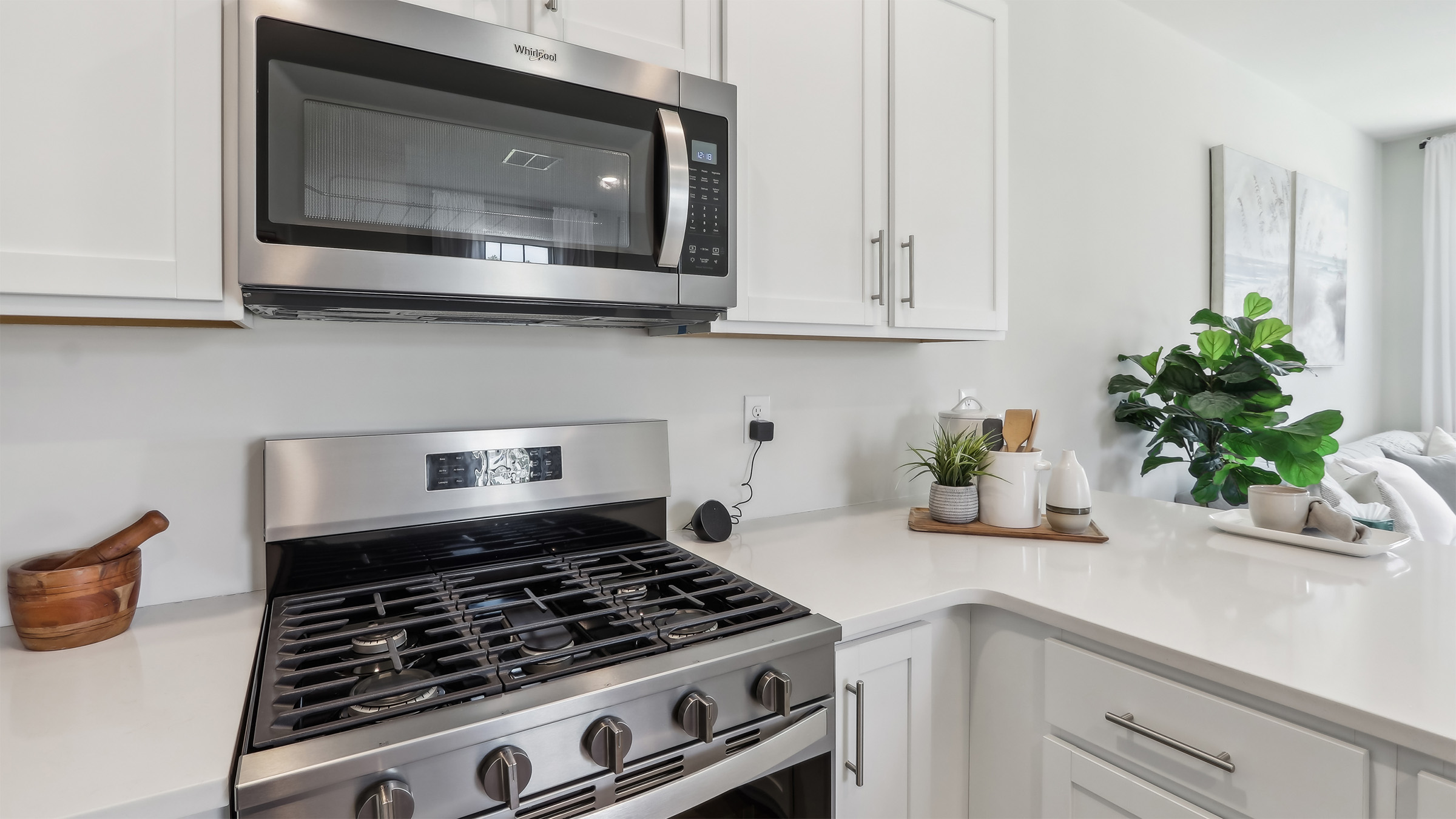 large kitchen island with white cabinetry, stainless steel appliances, and large pantry