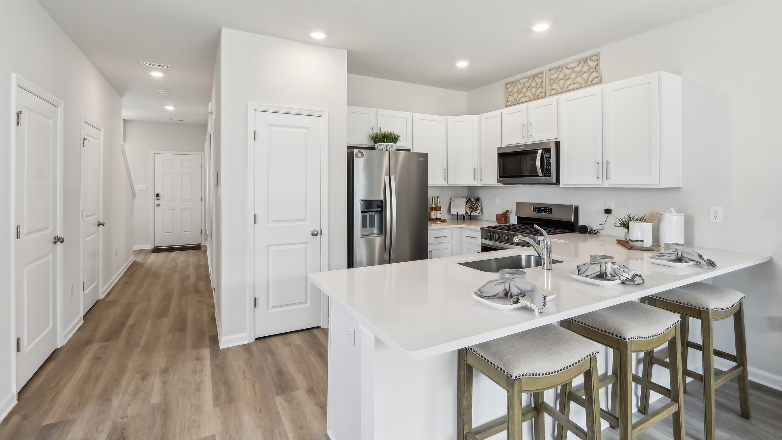 spacious island in the kitchen with white cabinetry and stainless steel appliances