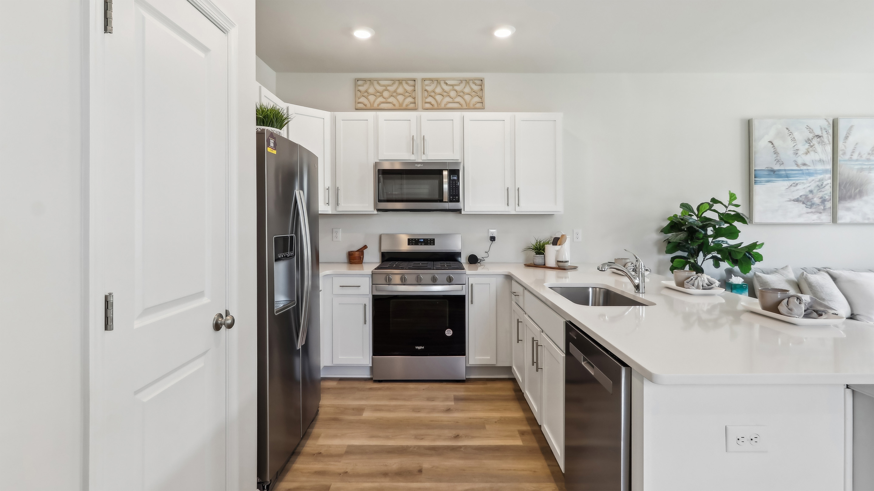 spacious island in the kitchen with white cabinetry and stainless steel appliances