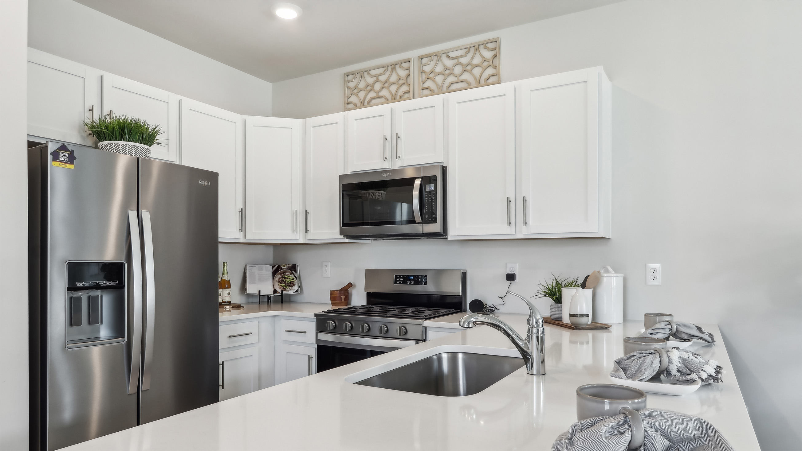 spacious island in the kitchen with white cabinetry and stainless steel appliances