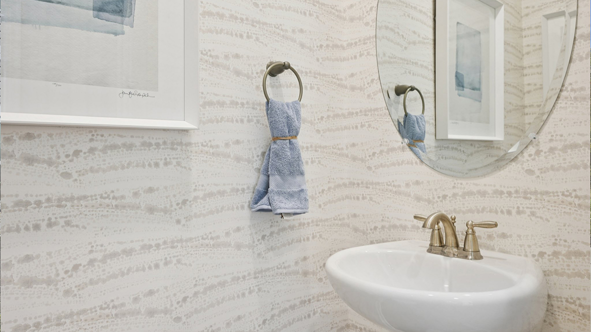 powder room on the main floor with tan wallpaper