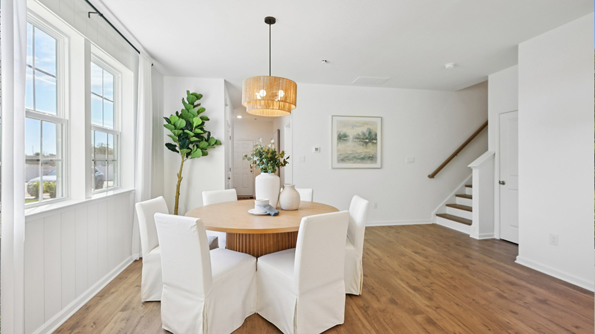 round table near the stairs and large windows