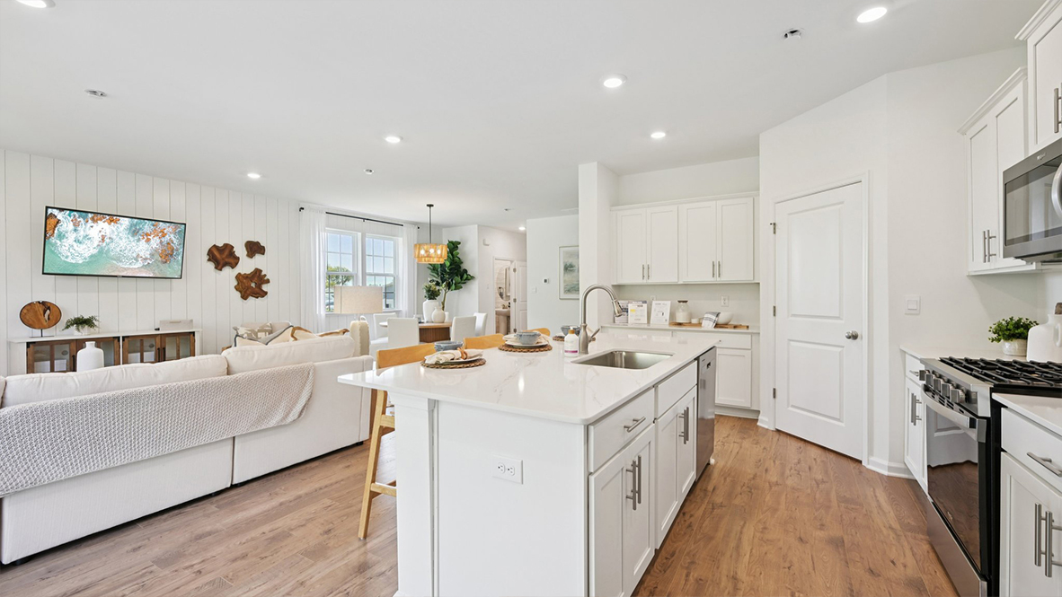 beautiful and spacious kitchen quartz island with white cabinetry and stainless steel appliances