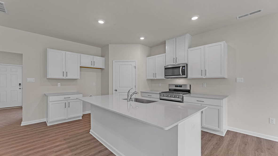 large kitchen with spacious white quartz island and white cabinetry