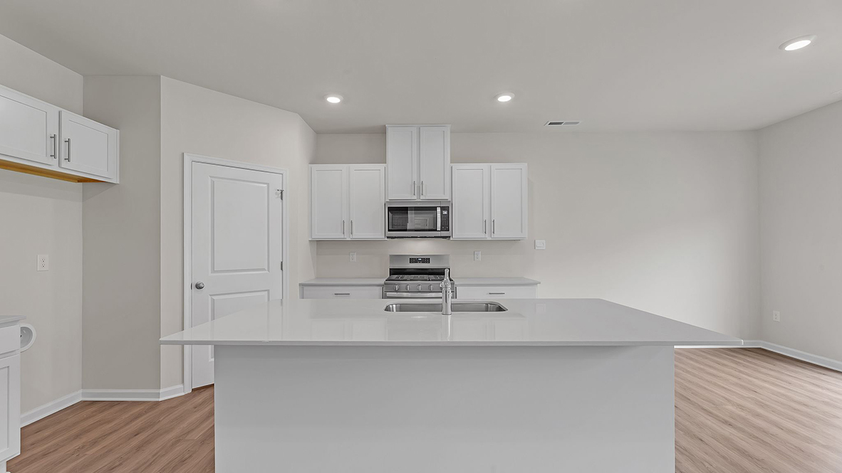 spacious kitchen island with white cabinetry