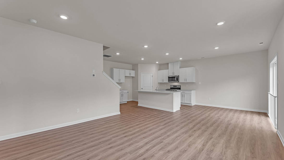 large open concept living room with spacious kitchen behind