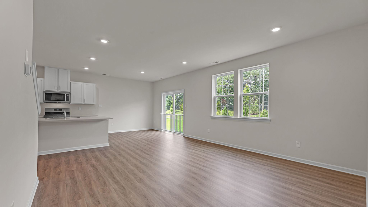 large open concept living room with spacious kitchen behind