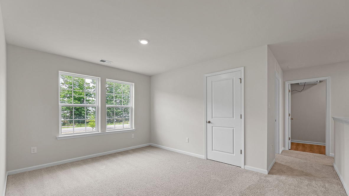spacious bedroom with large windows and full bath