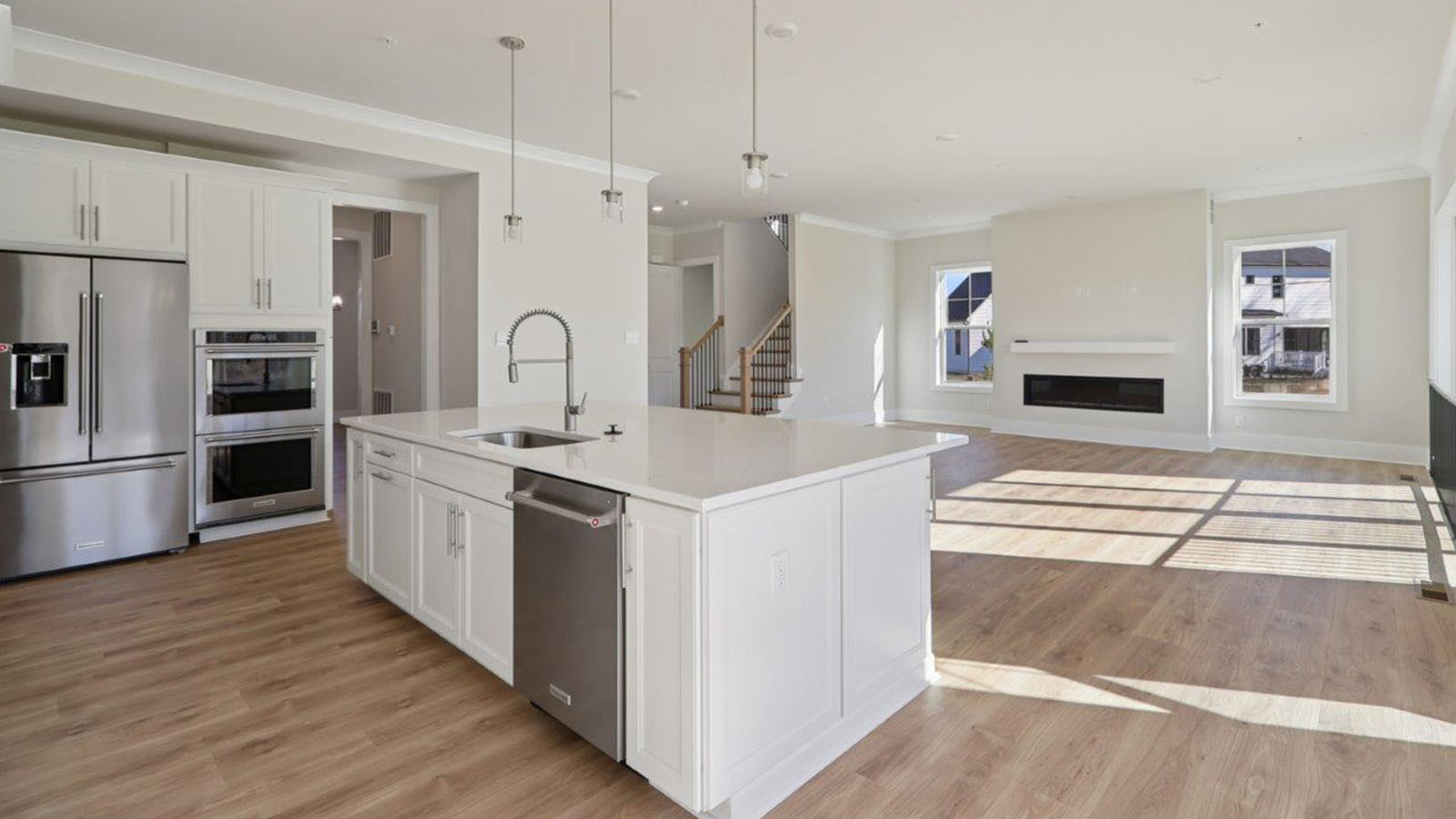 open concept living room and spacious kitchen with large island and light fixture