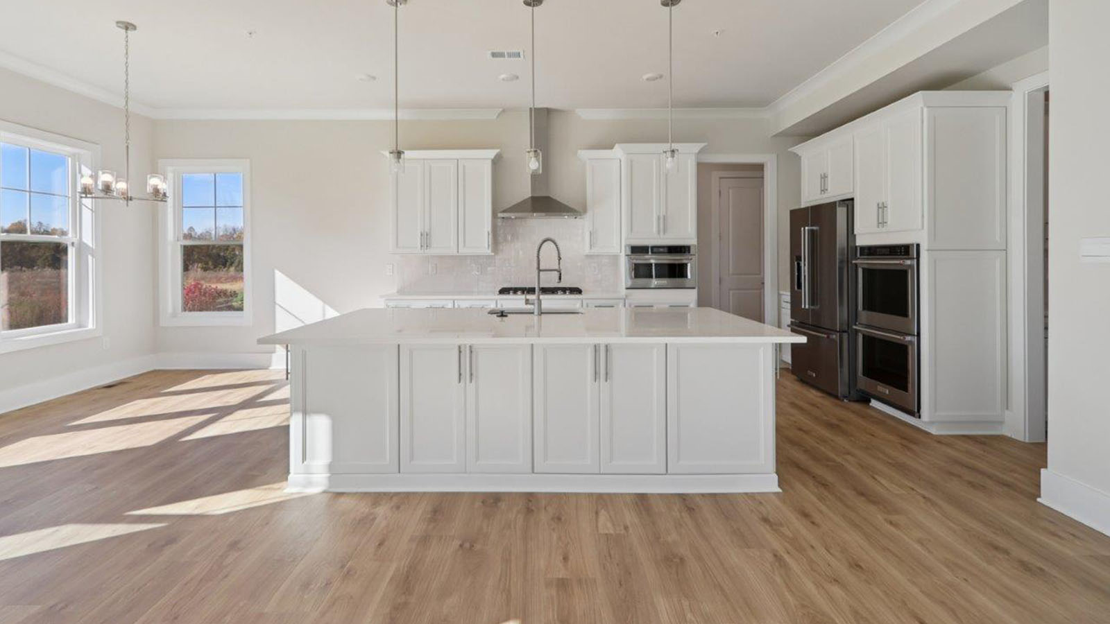open concept living room and spacious kitchen with large island and light fixture