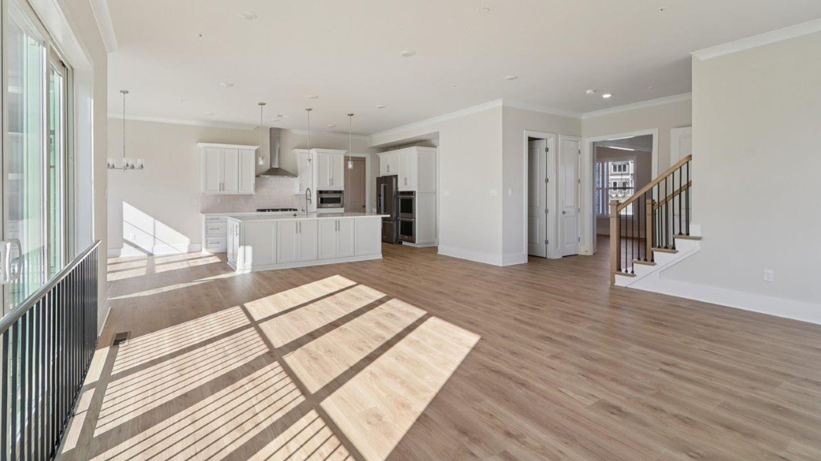 spacious kitchen with large quartz island and white cabinetry
