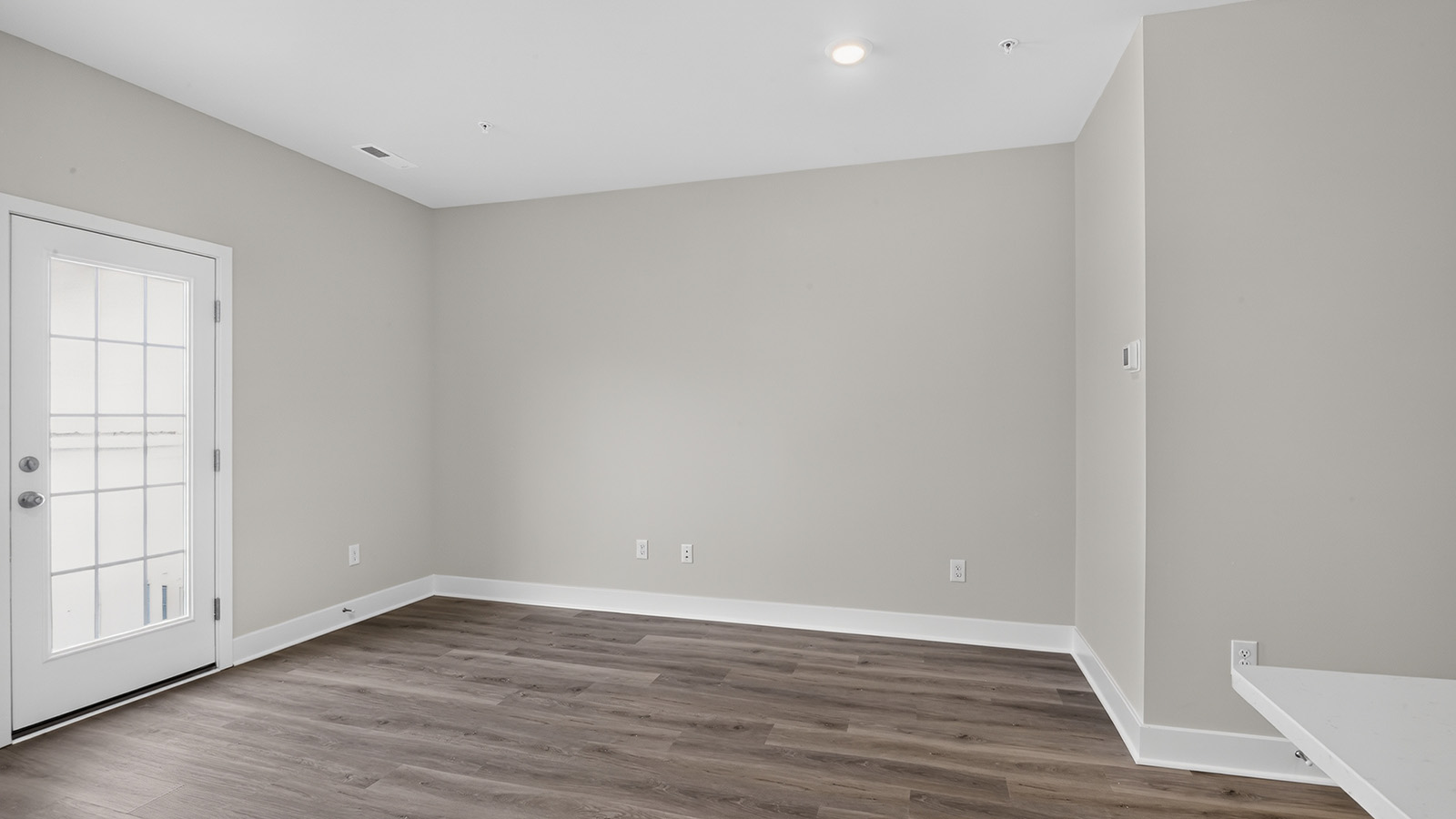 spacious open concept living room with medium toned hardwood throughout