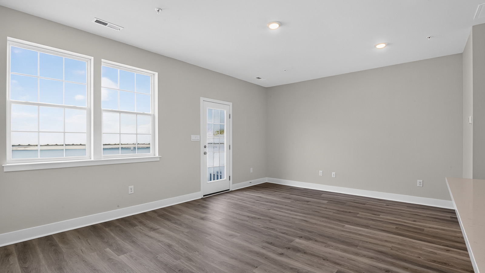 spacious open concept living room with medium toned hardwood throughout
