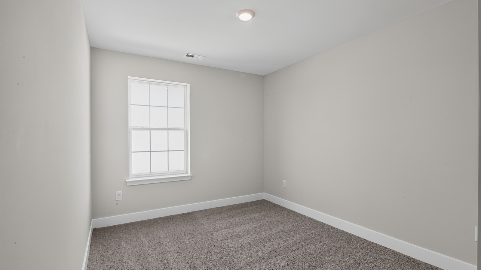 spacious bedroom with large windows and closet space