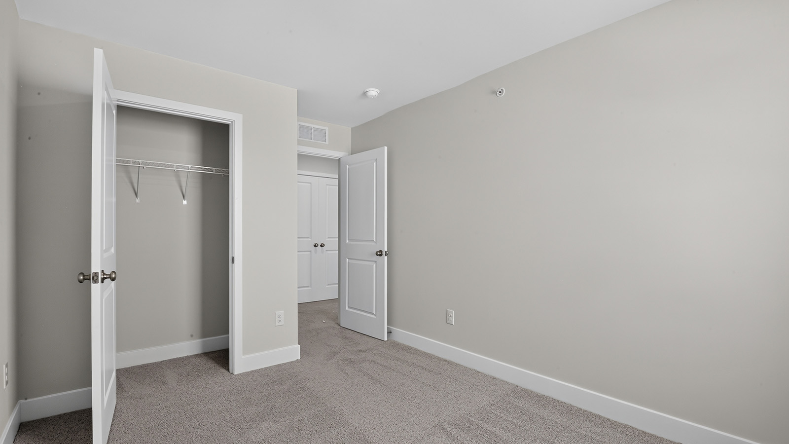 spacious bedroom with large windows and closet space