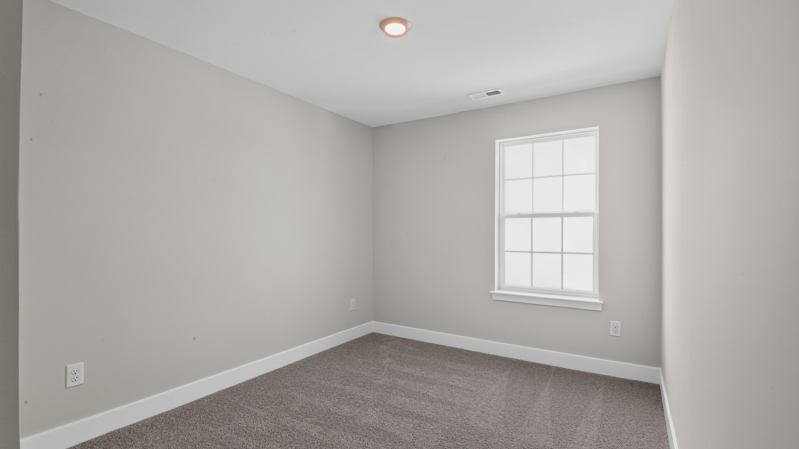 spacious bedroom with large windows and closet space