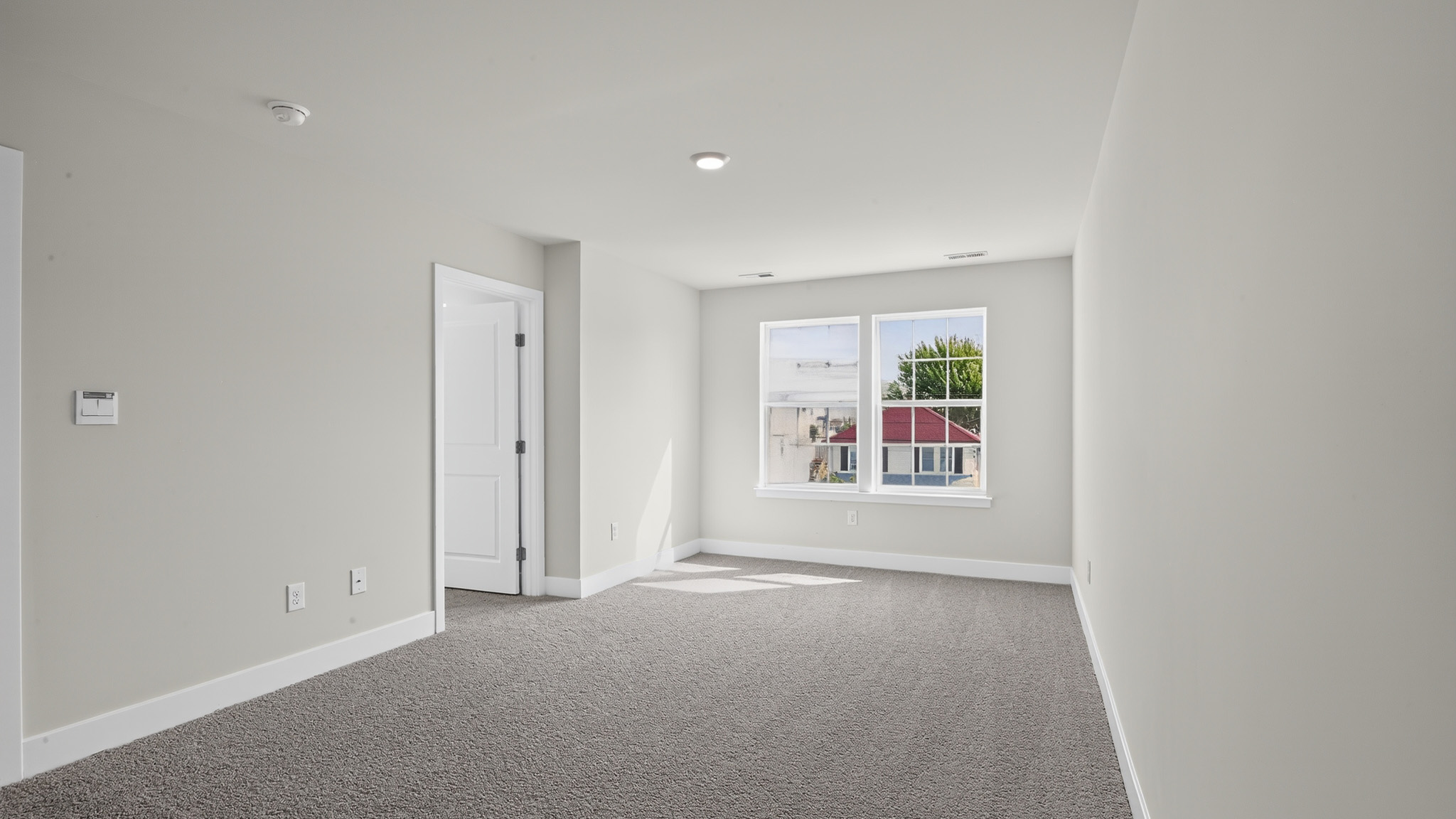 spacious primary suite with large windows, en suite bath, and walk in closet