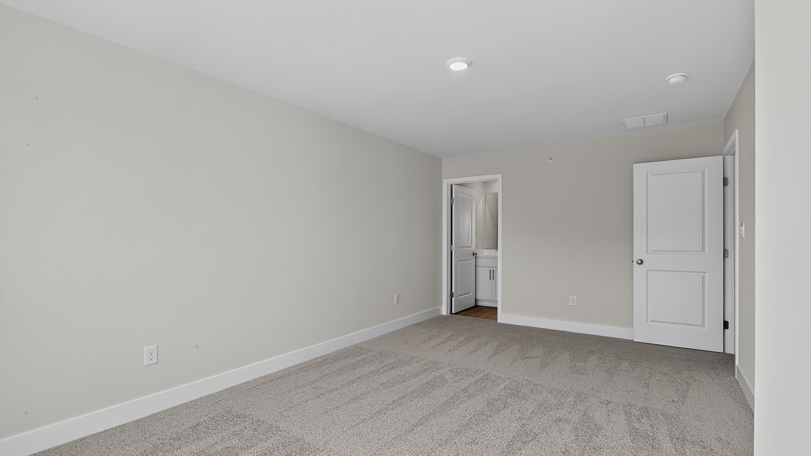 spacious primary suite with large windows, en suite bath, and walk in closet