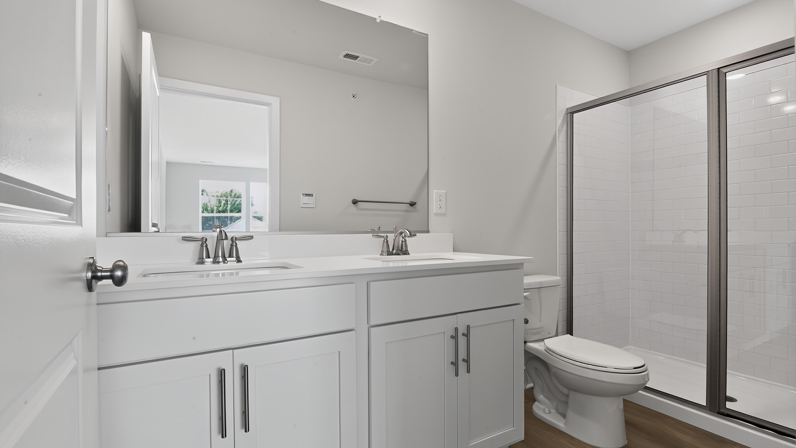 spacious primary suite with large windows, en suite bath, and walk in closet