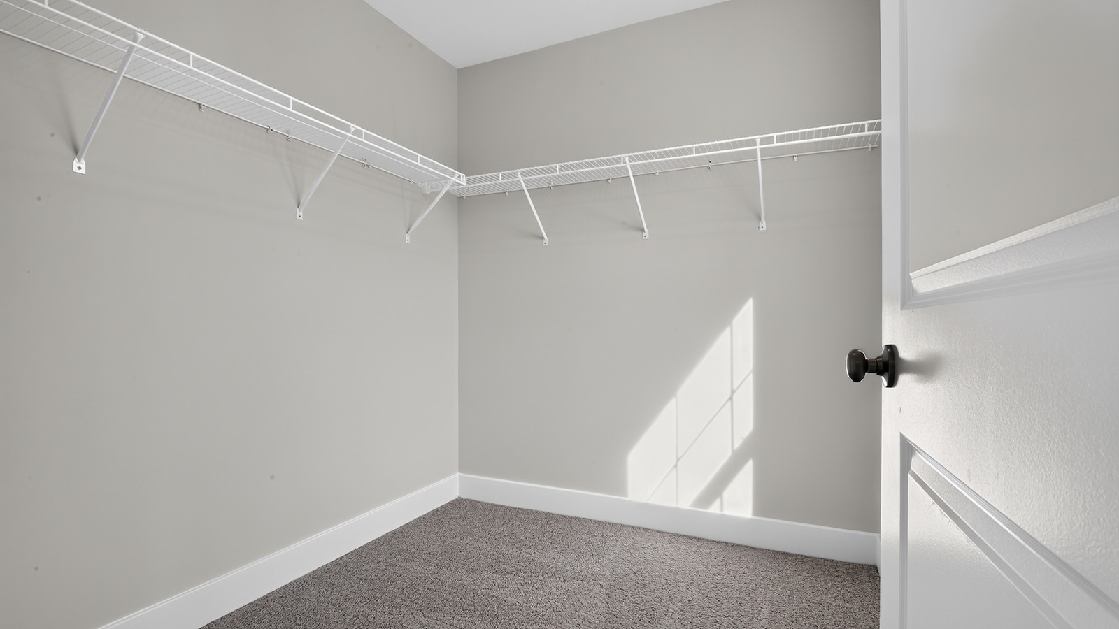 spacious primary suite with large windows, en suite bath, and walk in closet